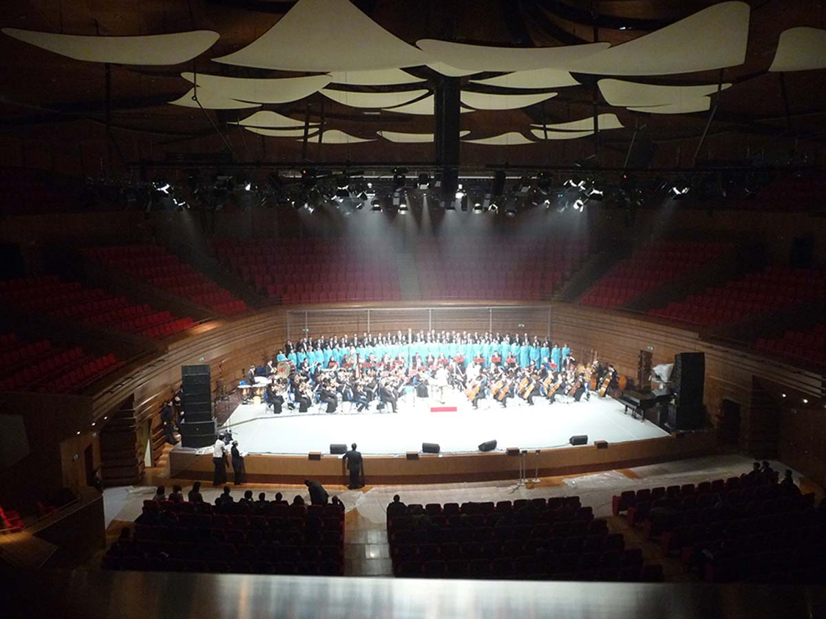 Concerto di orchestra e coro sul palco dell auditorium di Astana con luci sceniche