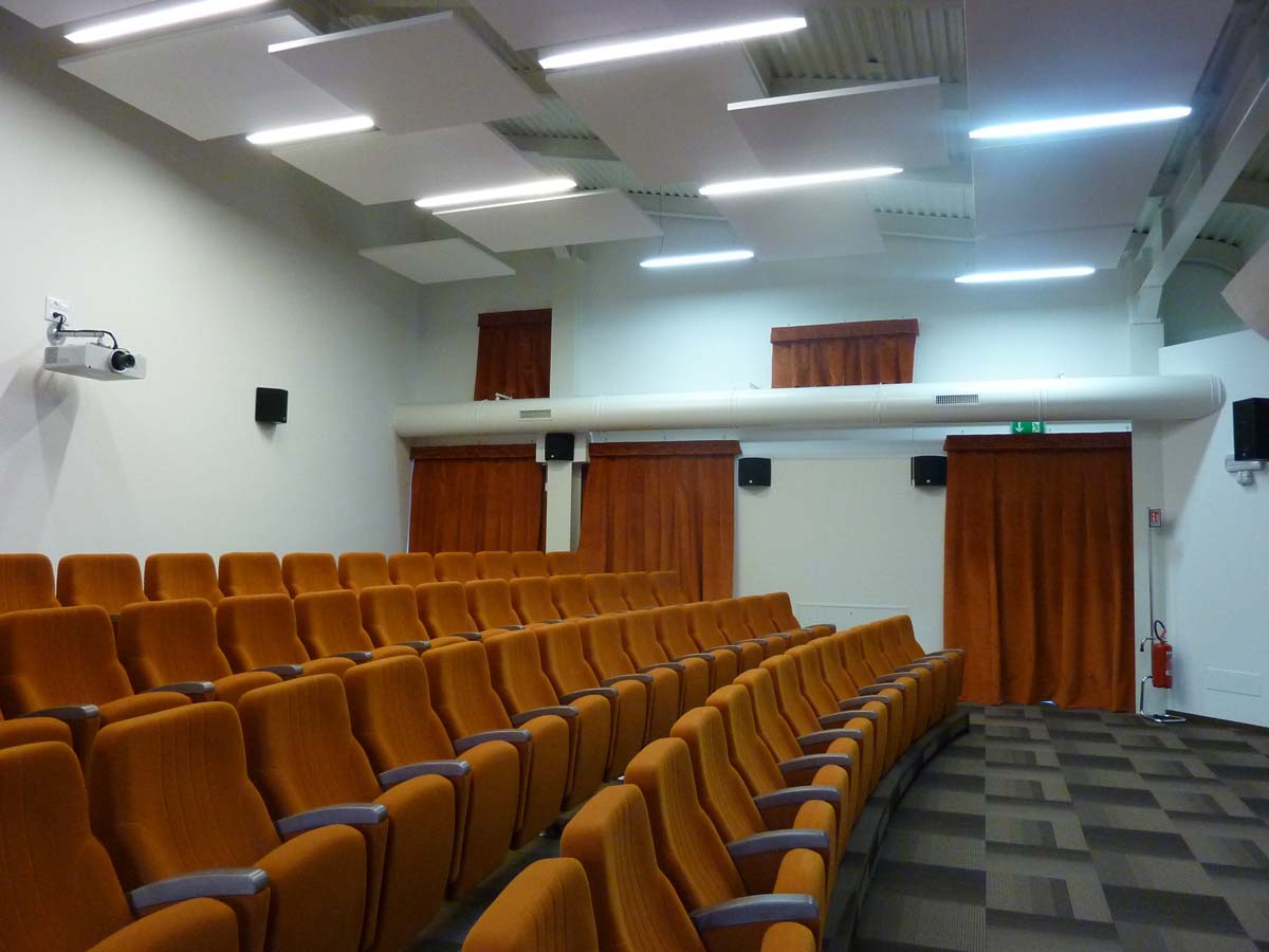 Platea dell auditorium DIAL di Pergine con poltrone arancioni e pannelli fonoassorbenti a soffitto