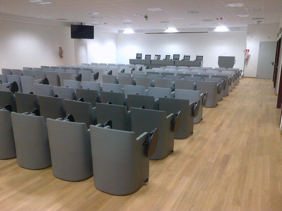 Sala conferenze USSL Feltre con poltrone grigie a scocca avvolgente e monitor a soffitto