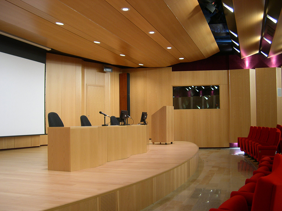 Podio relatori con microfoni, schermo proiezione e soffitto curvo in legno alla Camera di Commercio di Lecco