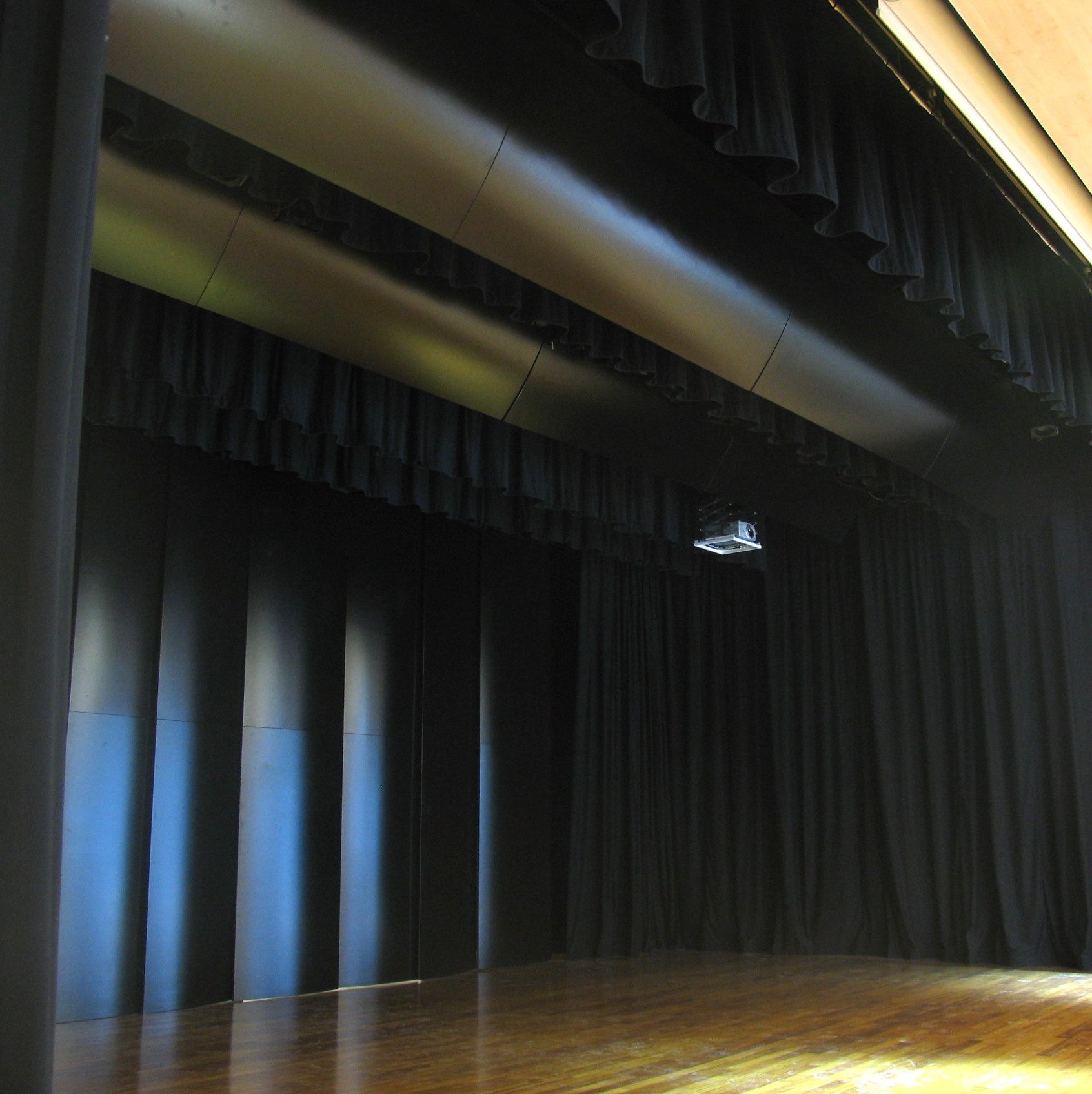 Palcoscenico con tendaggi neri, condotti acustici e proiettore nel teatro del Casino di Campione d Italia