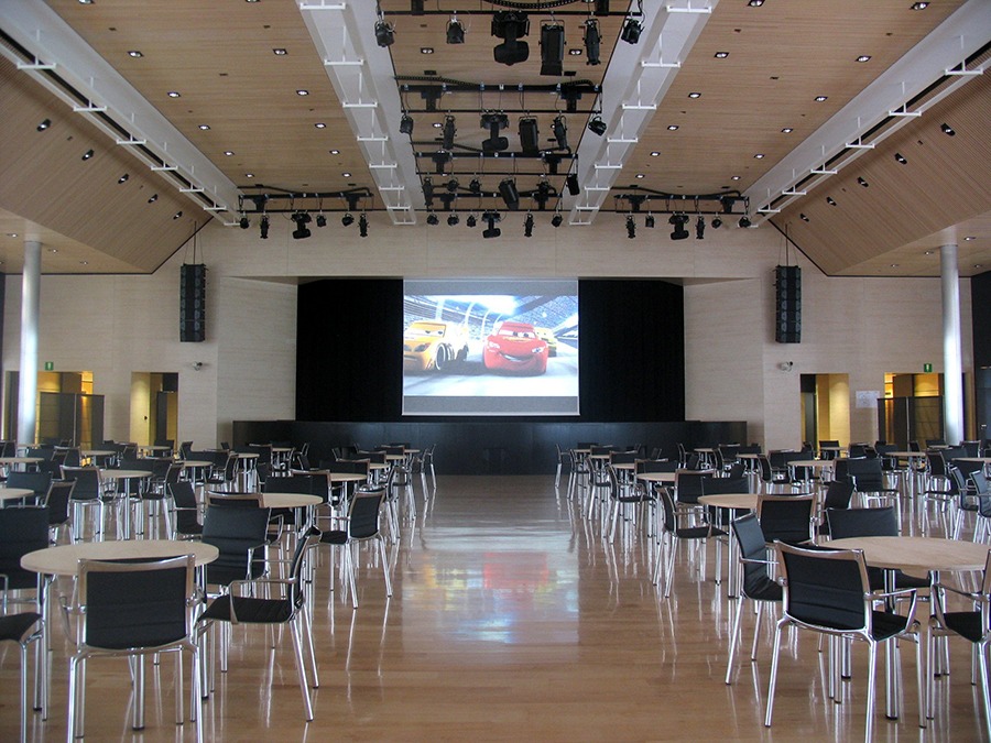 Sala eventi del Casino di Campione d Italia con tavoli, schermo di proiezione e impianto luci a soffitto