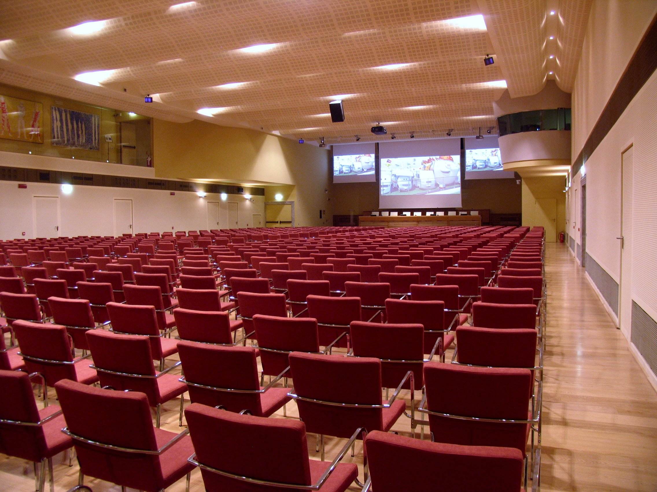 Vista panoramica della sala congressi di Villa Borromeo con centinaia di poltrone rosse e schermi