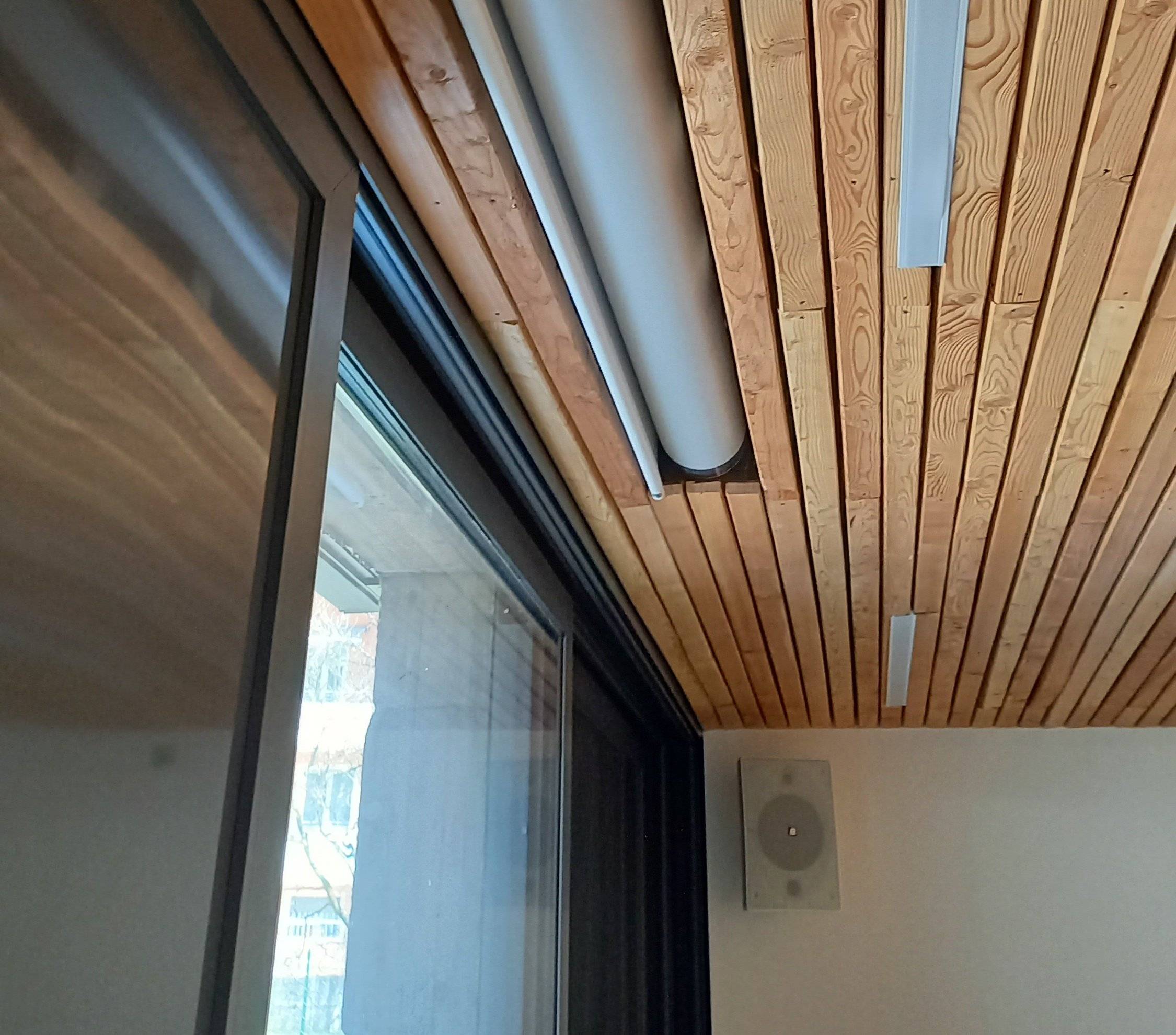 Dettaglio soffitto in legno con diffusore audio a parete al Centro Giovani di Pieve di Bono