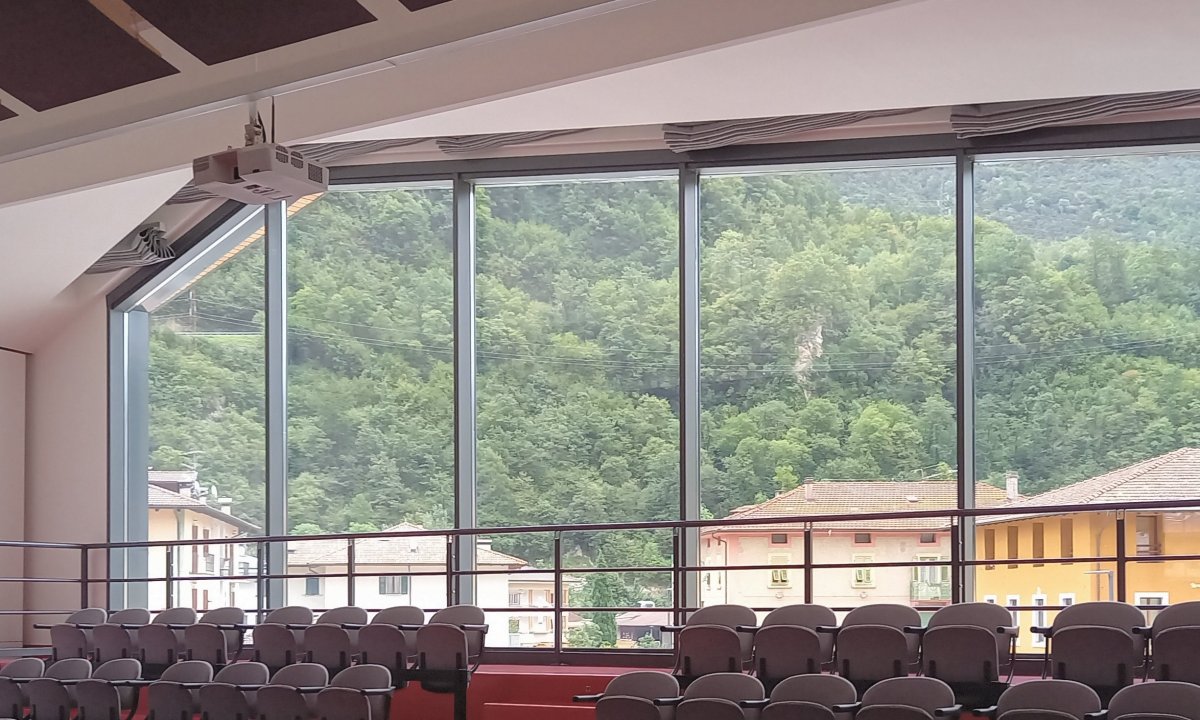 Vetrata panoramica con vista montagne e proiettore a soffitto al Centro Giovani di Pieve di Bono