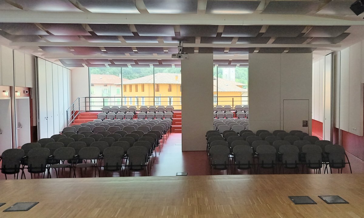 Sala con sedie e pareti mobili con pannelli acustici a soffitto al Centro Giovani di Pieve di Bono