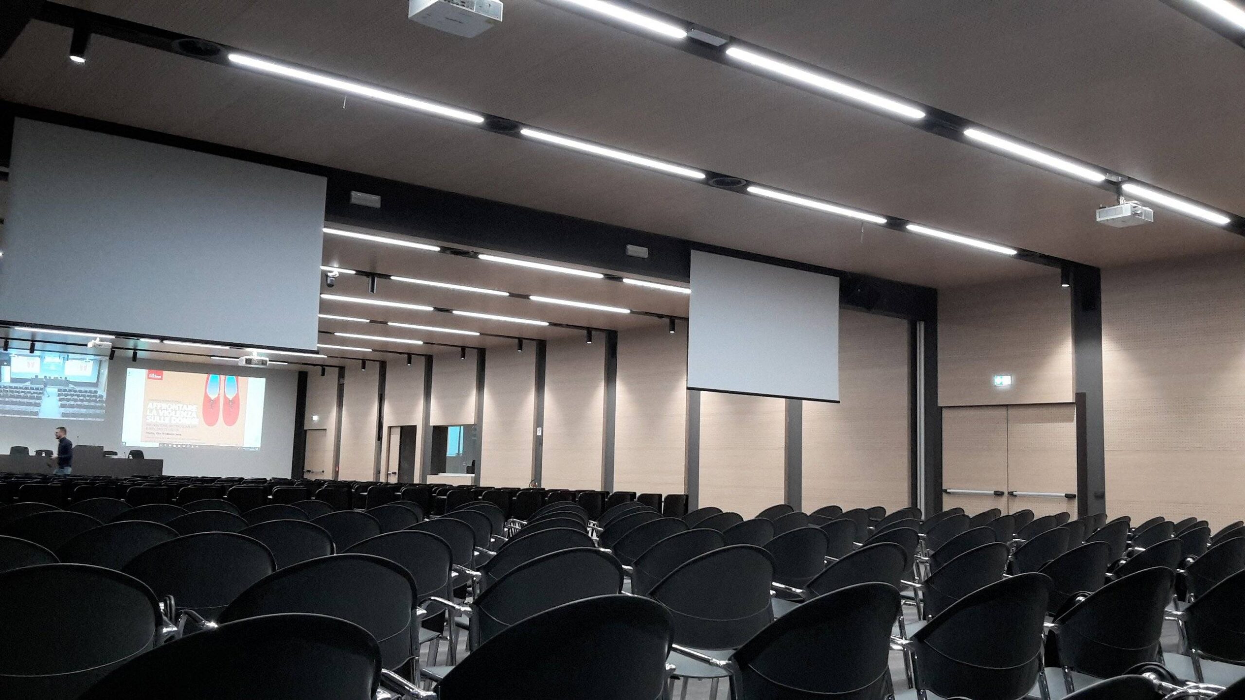 Sala conferenze del Centro Studi Erickson con sedie nere, schermi e pannelli fonoassorbenti