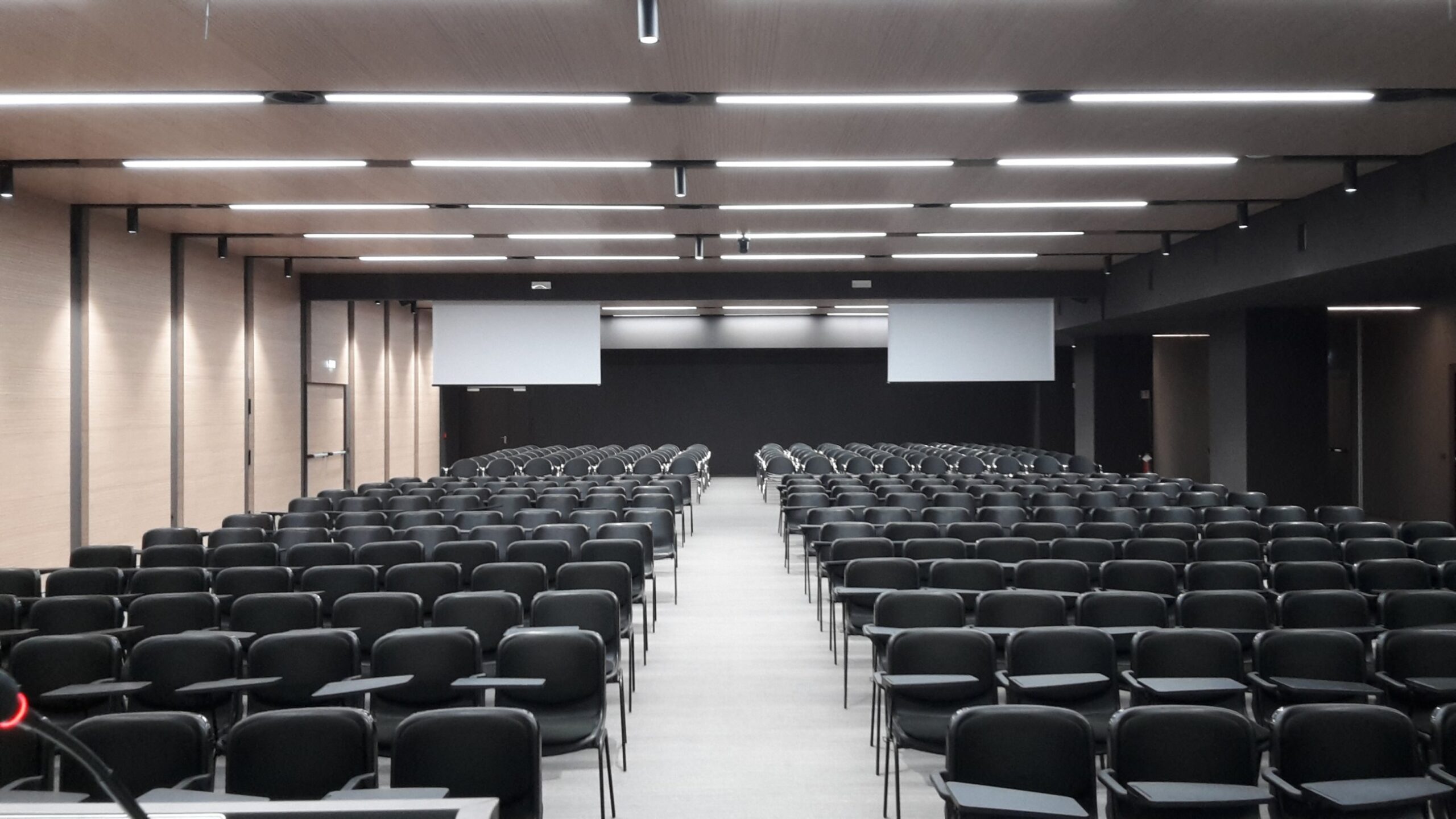Auditorium del Centro Studi Erickson con file di sedie nere, schermi e illuminazione a LED