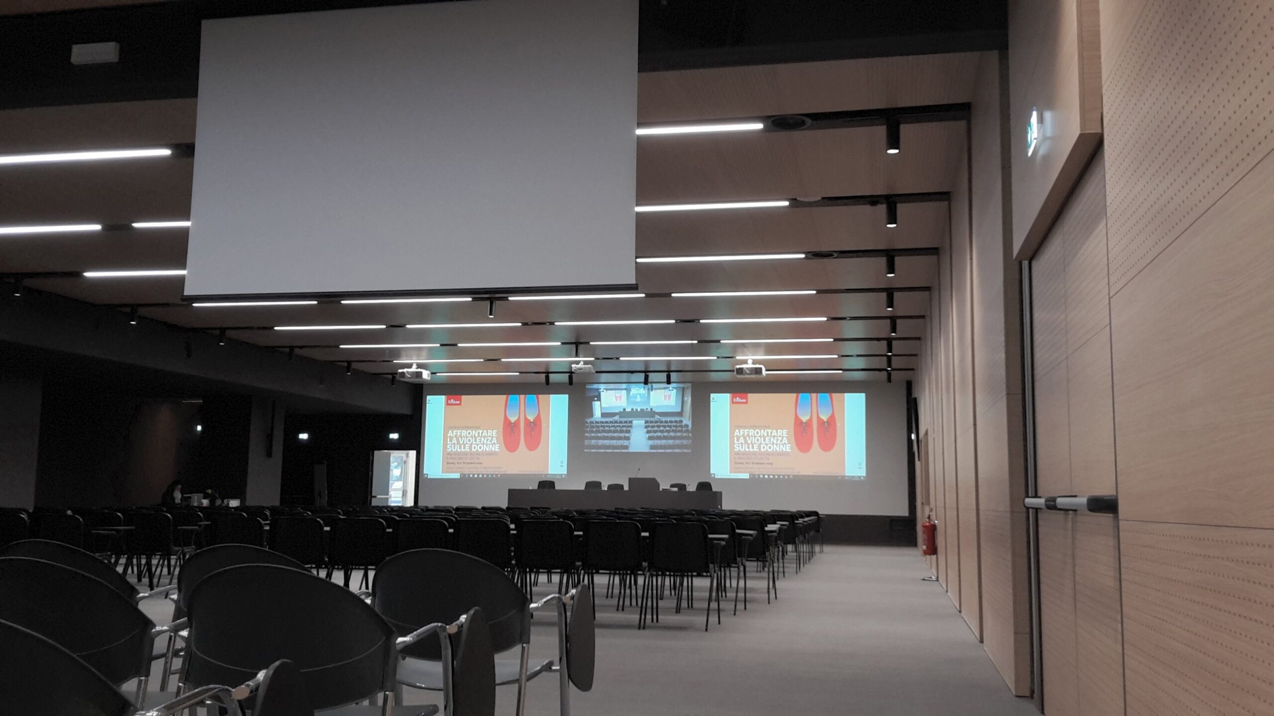 Vista laterale della sala del Centro Studi Erickson con schermo motorizzato e proiezioni multiple