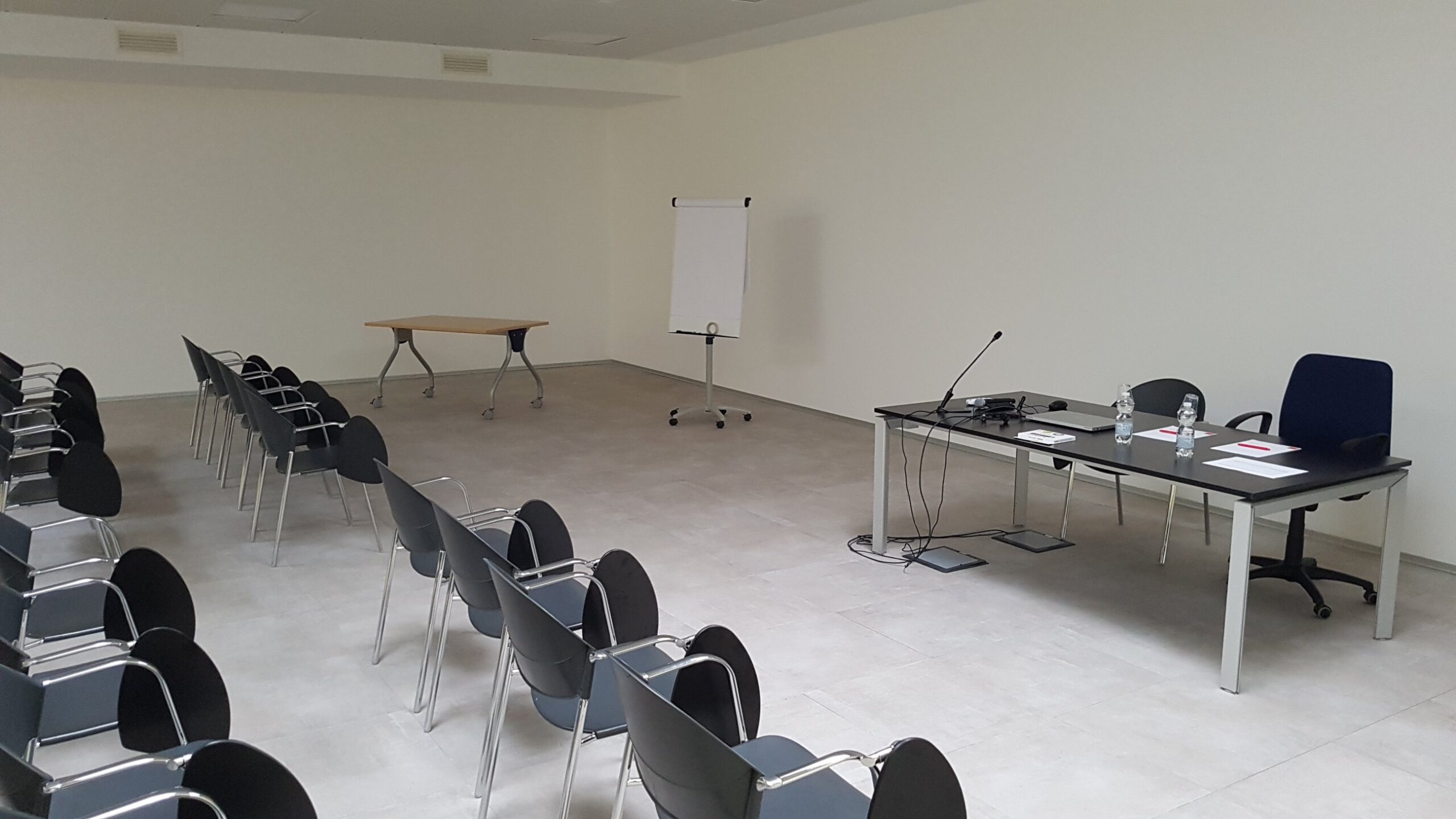 Sala riunioni del Centro Studi Erickson con sedie, tavolo relatori, lavagna e microfono