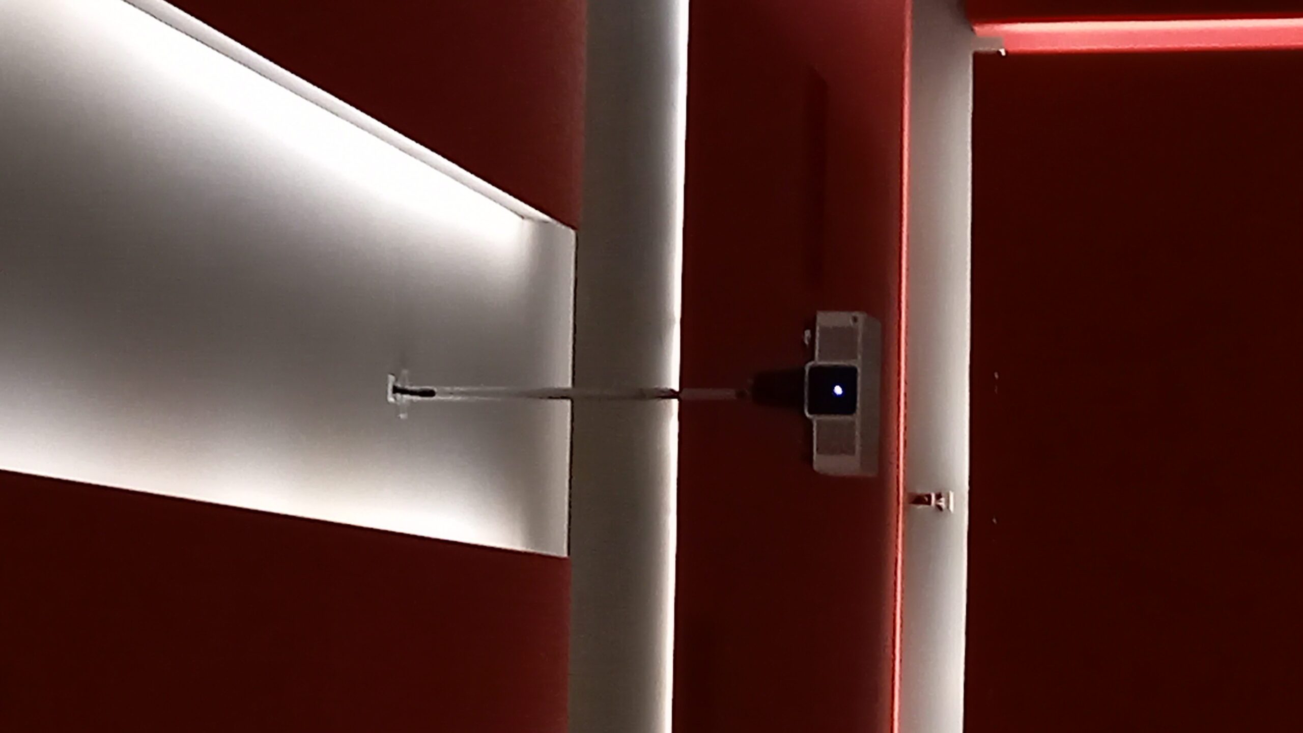 Dettaglio del proiettore a soffitto con pareti rosse e illuminazione LED al Cinema Teatro Ferrari di Galbiate