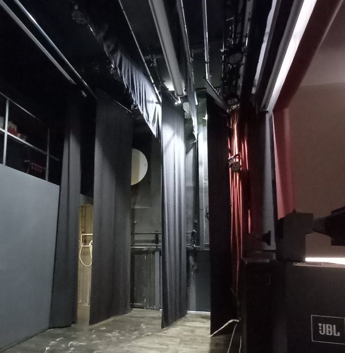 Backstage del Cinema Teatro Ferrari di Galbiate con quinte nere, tralicci e diffusore JBL