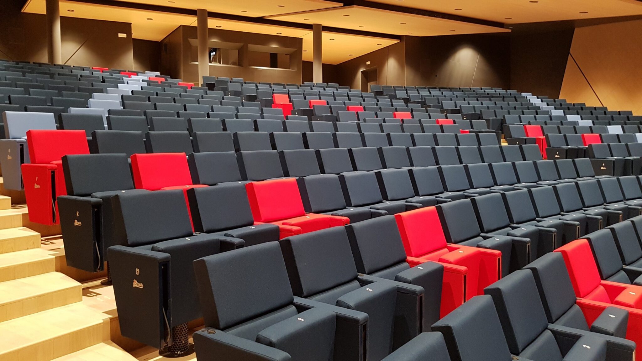 Platea con poltrone blu e rosse nell auditorium della Cooperativa Sant Orsola
