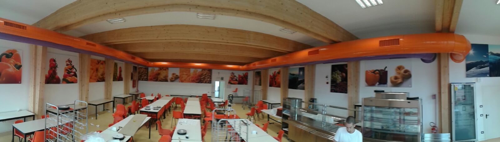 Vista panoramica della mensa con trattamento acustico, soffitto in legno lamellare e sedie arancioni