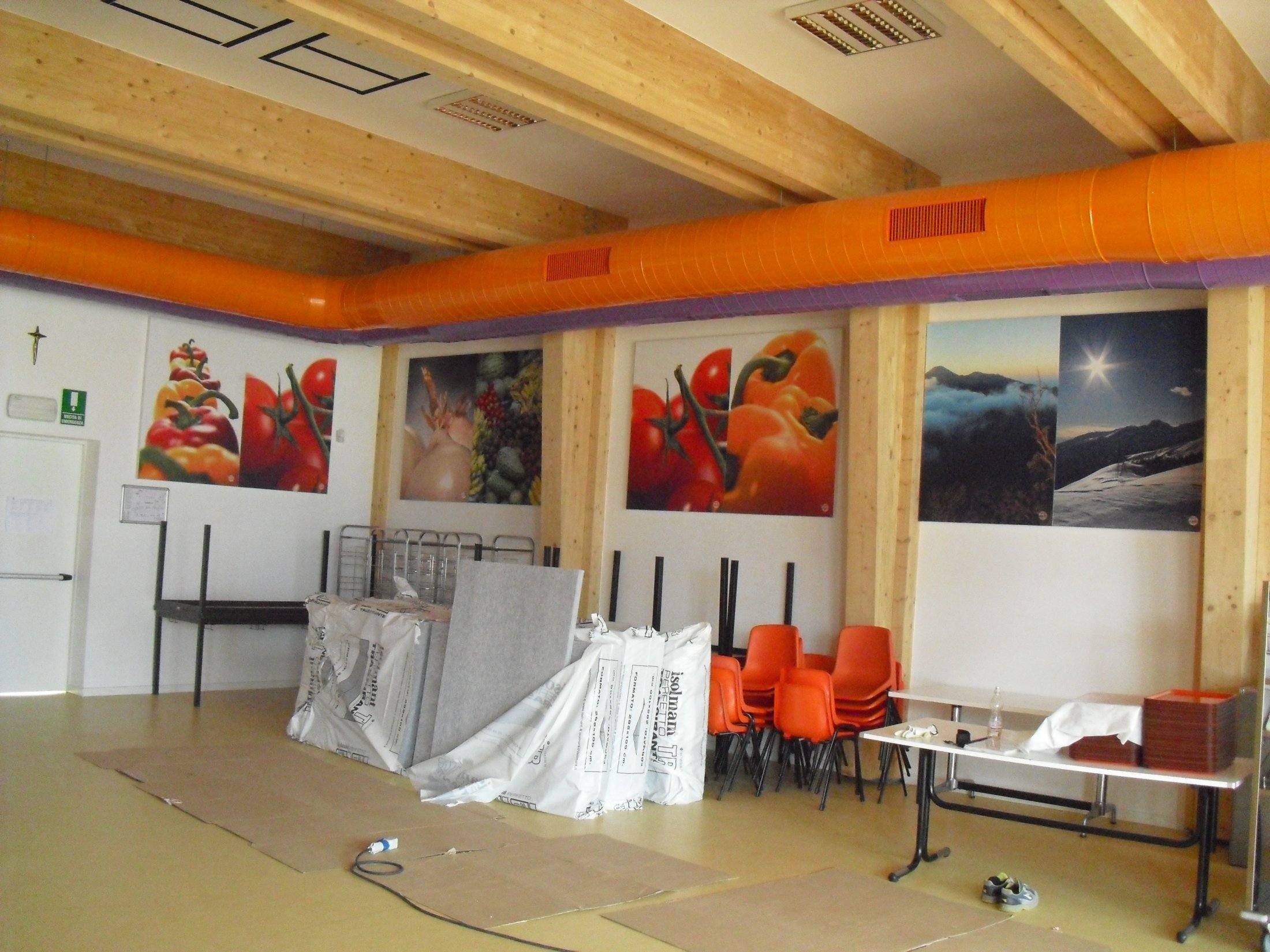 Fase di installazione dei pannelli fonoassorbenti nella mensa con struttura in legno lamellare