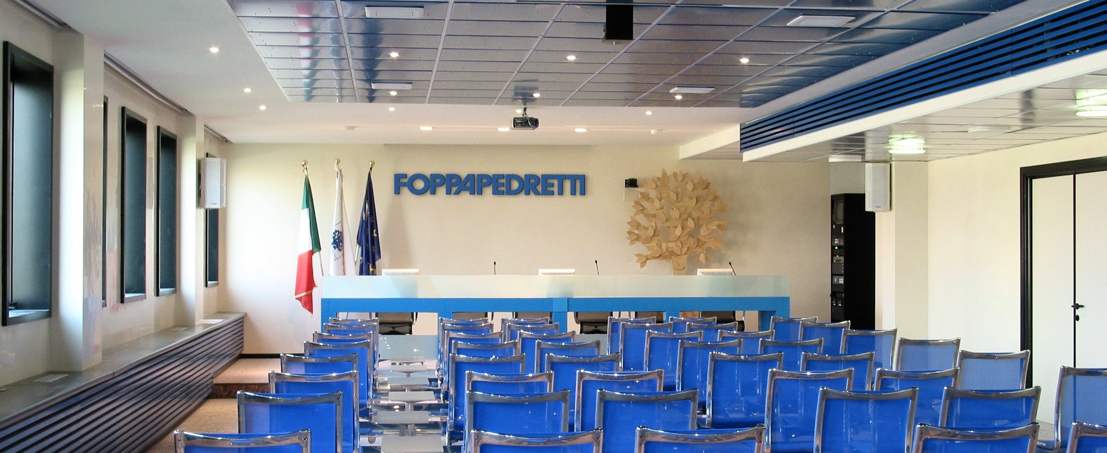 Vista panoramica della sala meeting Foppa Pedretti con pannelli acustici e logo a parete
