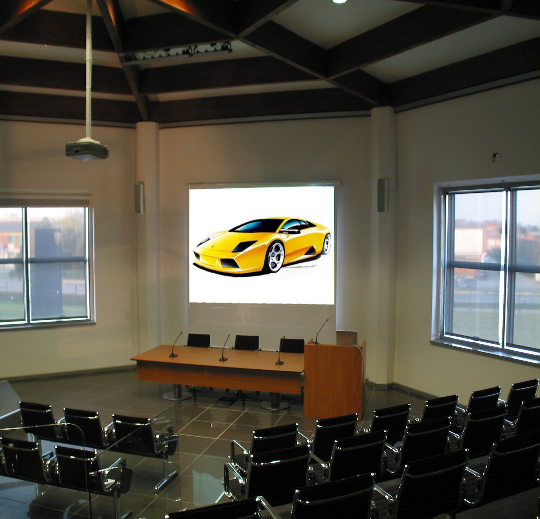 Sala conferenze Lamborghini a Bologna con proiettore, schermo e sedute nere in pelle