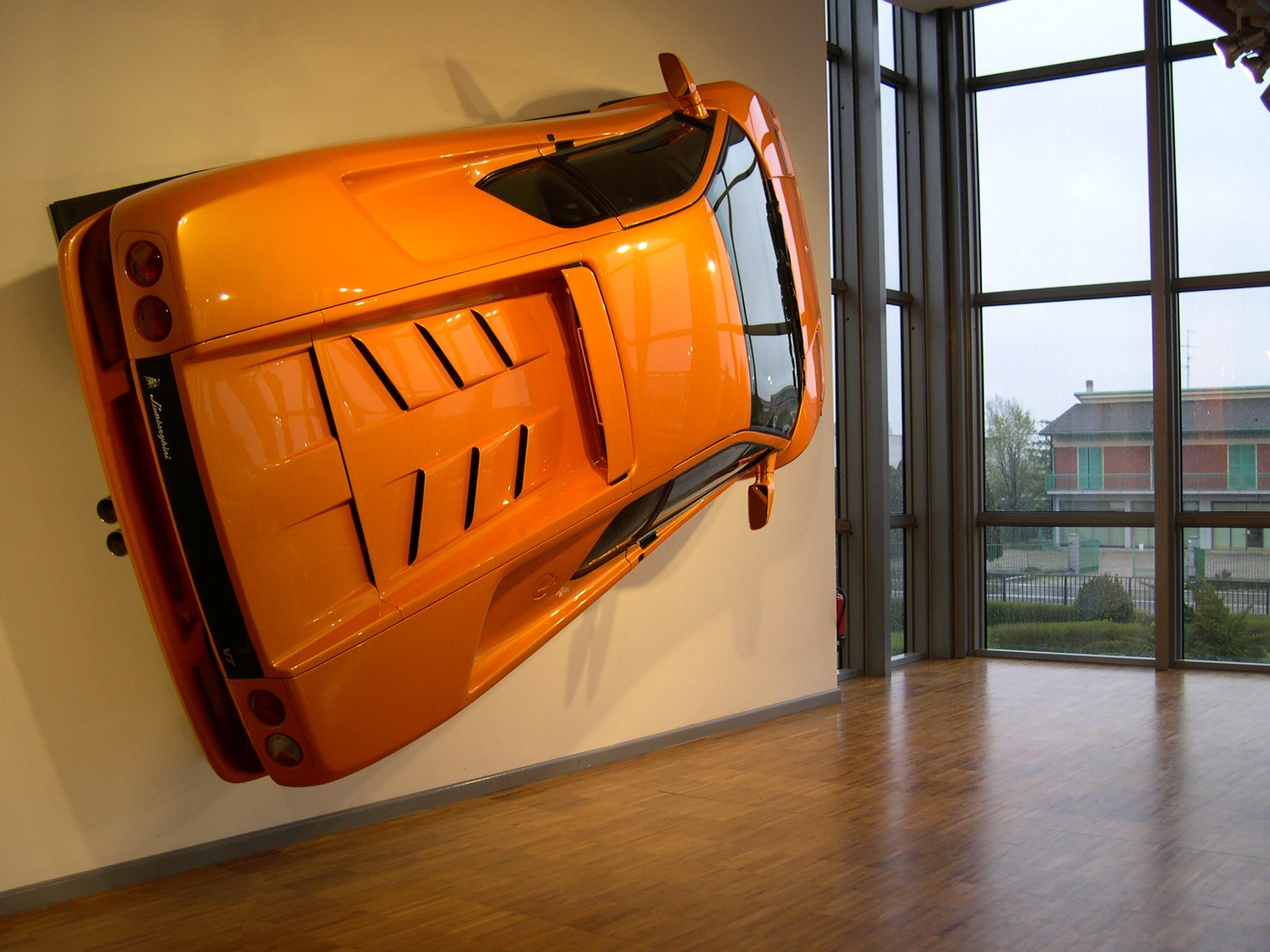 Vista laterale della Lamborghini arancione appesa alla parete nel museo Lamborghini di Bologna