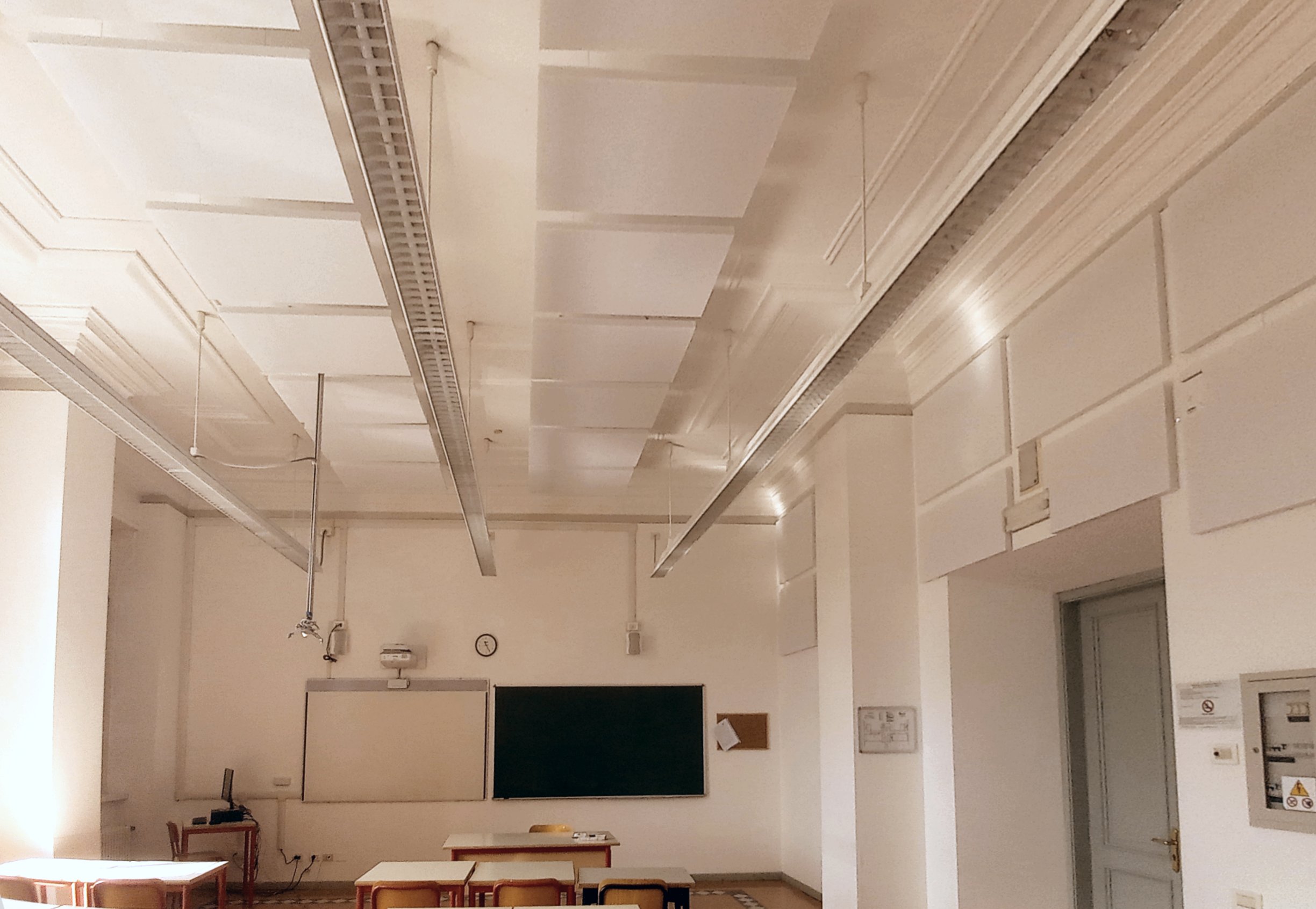 Aula scolastica con pannelli acustici a soffitto e parete, lavagna e proiettore al Liceo Galilei di Trento