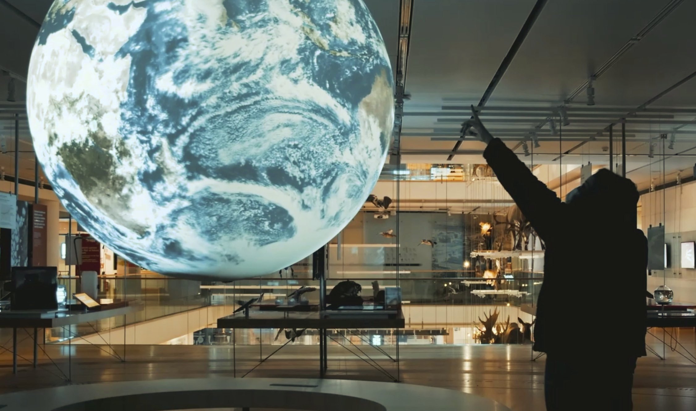 Globo terrestre luminoso sospeso nello spazio espositivo immersivo del MUSE di Trento