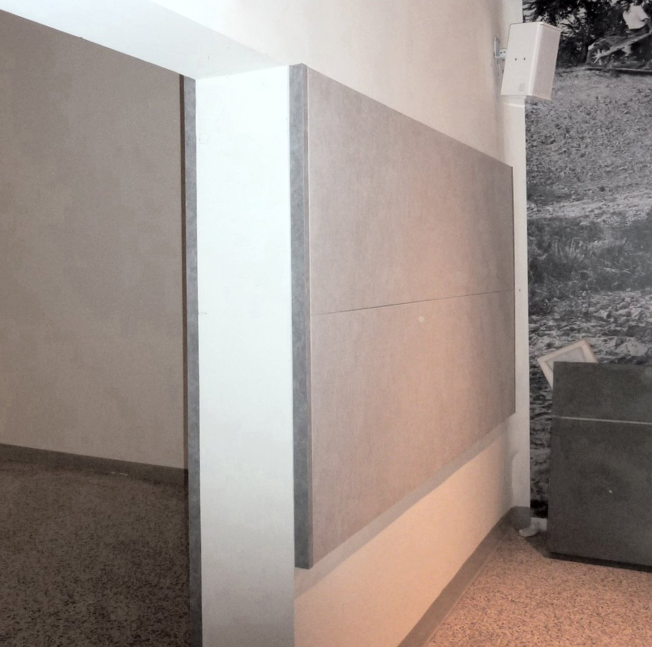 Pannelli fonoassorbenti e diffusore audio installati su parete del Museo Guareschi