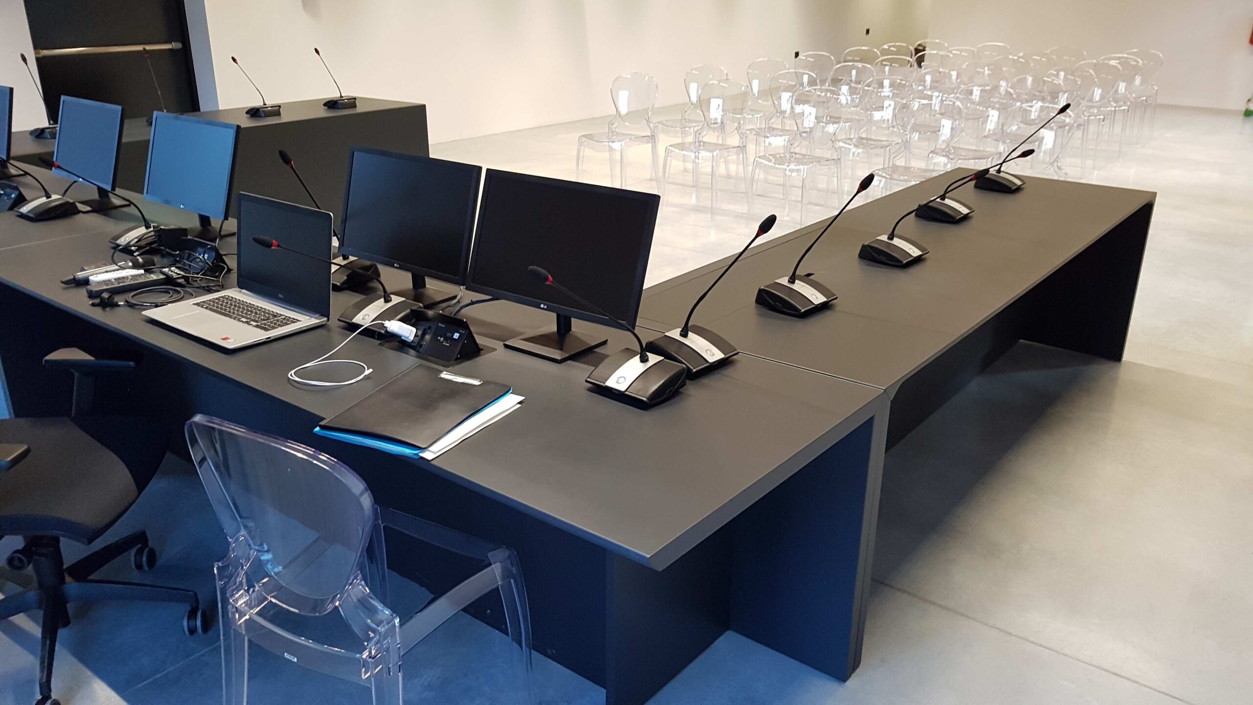 Postazione presidenza con monitor, microfoni e laptop nella sala consigliare di Torbole
