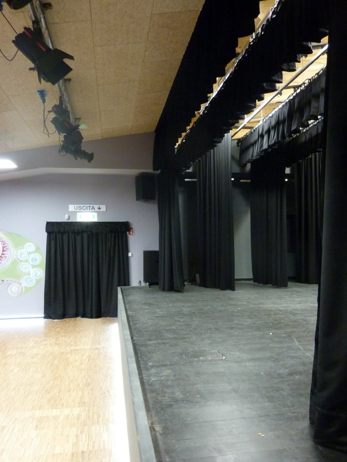 Palcoscenico con quinte nere, fari teatrali e americana luci nella sala polifunzionale di Gardolo