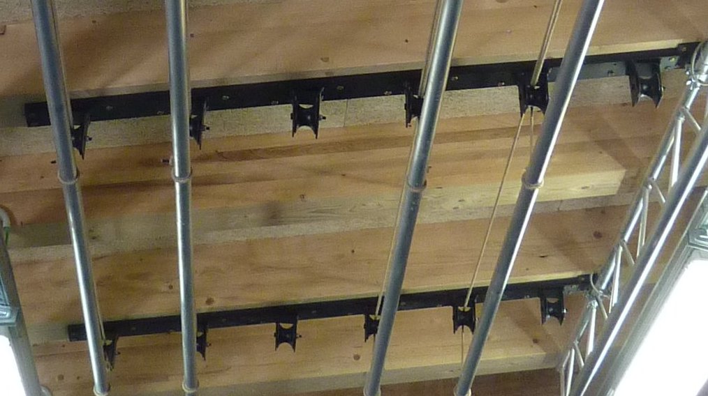 Dettaglio strutture a soffitto con supporti per fari e americana nella sala polifunzionale di Gardolo