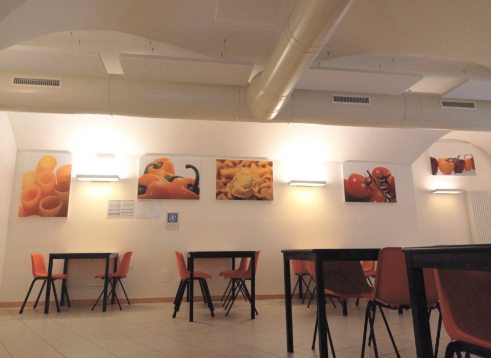 Mensa scolastica di Ville d'Anaunia con pannelli fonoassorbenti colorati e stampe alimentari a parete