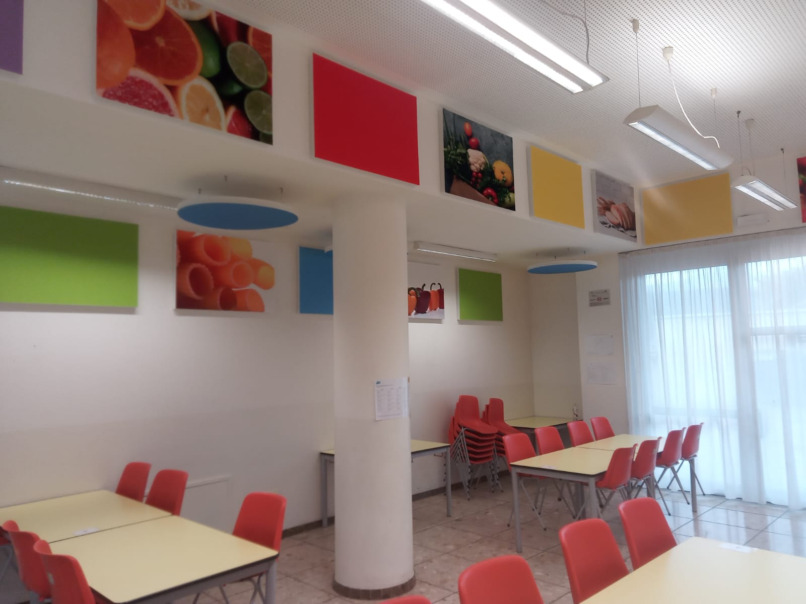 Mensa delle scuole primarie di Ville d'Anaunia con pannelli acustici colorati e stampati alle pareti