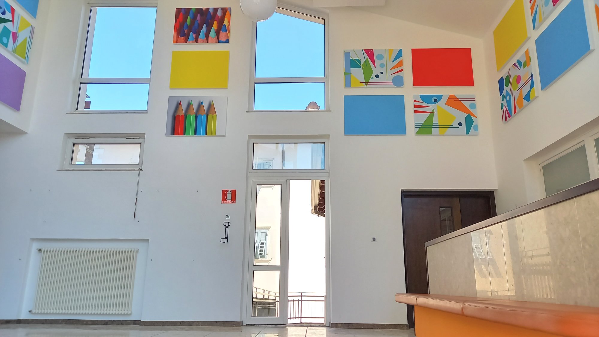 Ingresso della scuola primaria di Ville d'Anaunia con pannelli acustici decorativi multicolore
