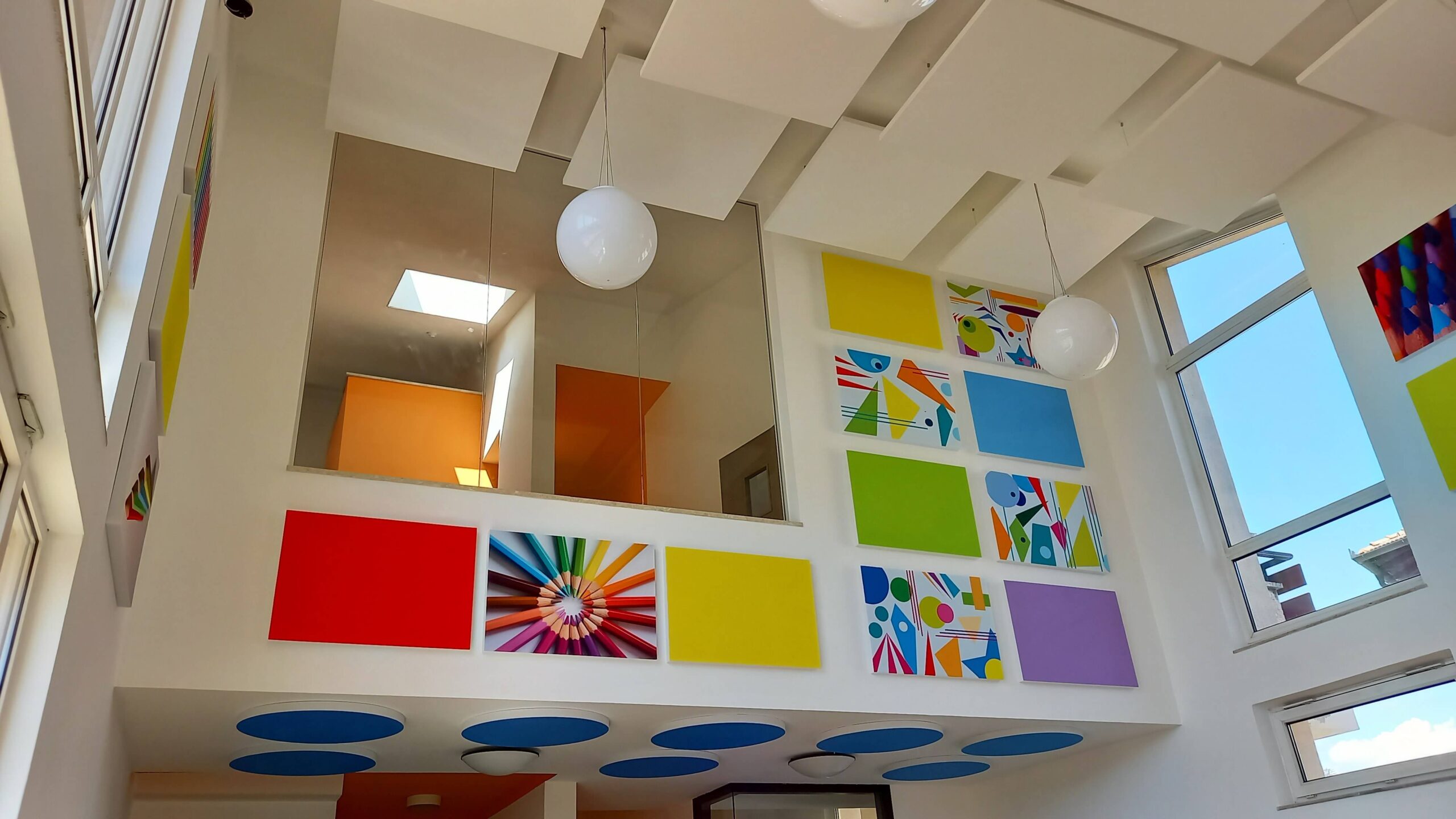 Pannelli fonoassorbenti colorati e dischi acustici blu a soffitto nella scuola di Ville d'Anaunia