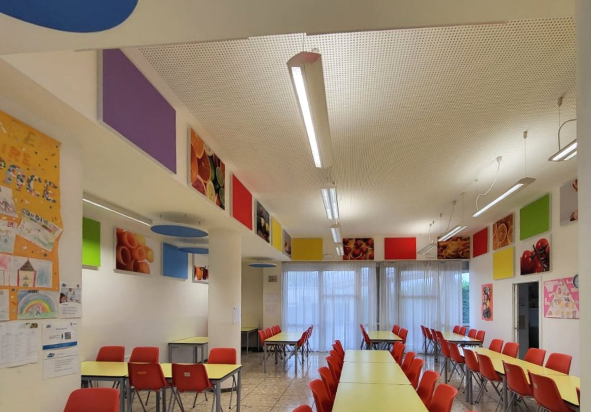 Vista panoramica della mensa scolastica con pannelli acustici decorativi a Ville d'Anaunia