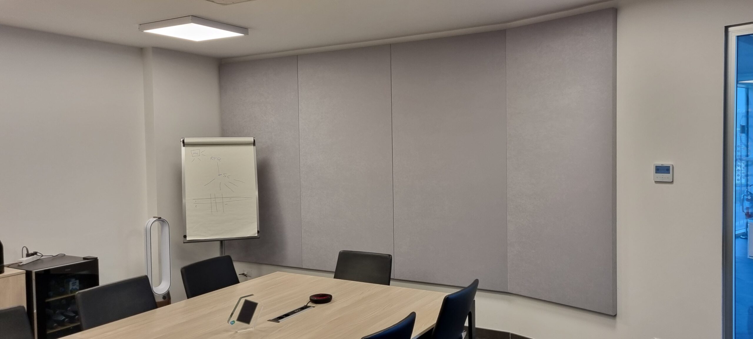 Pannelli fonoassorbenti grigi a parete curva nella sala riunioni Solid Power a Pergine Valsugana