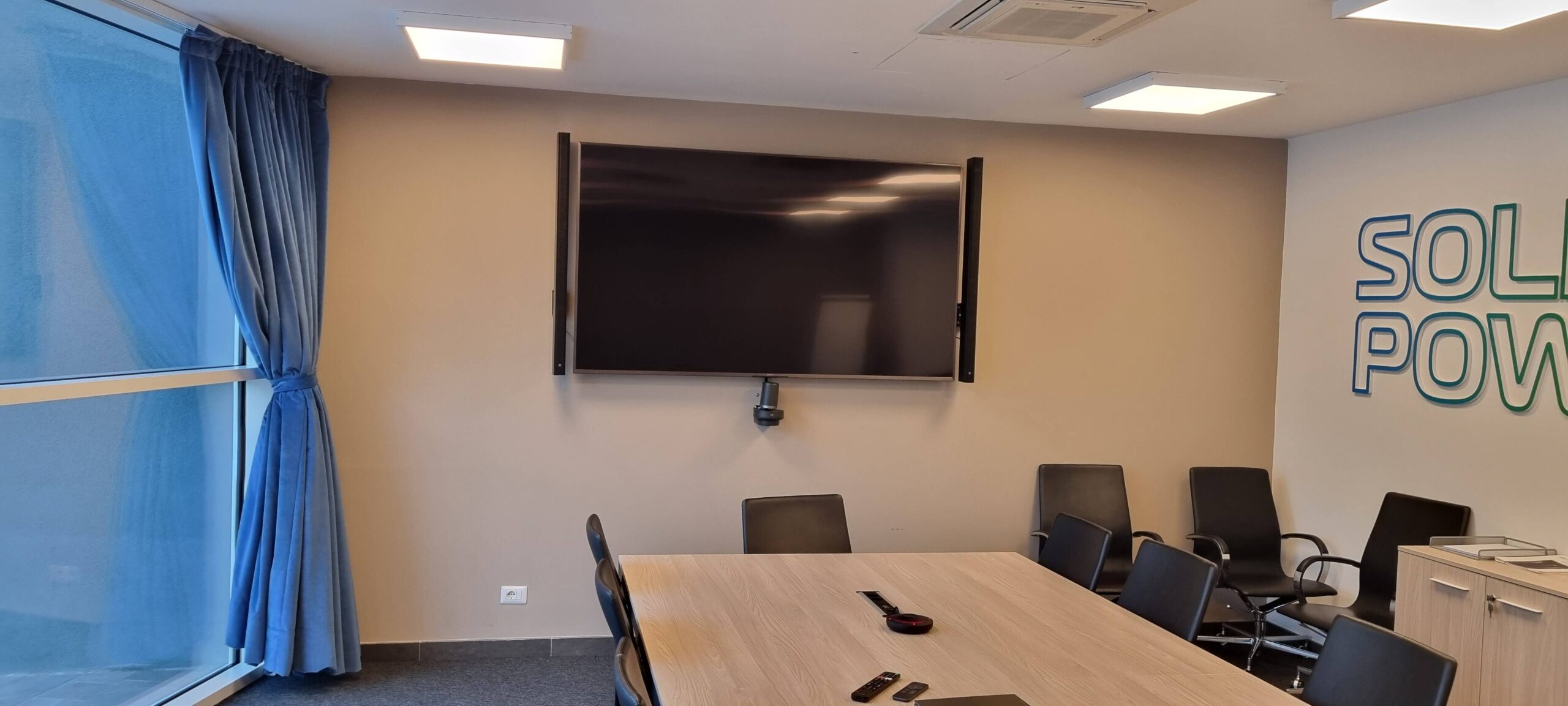 Sala conferenze Solid Power Pergine con monitor a parete, videocamera e logo aziendale