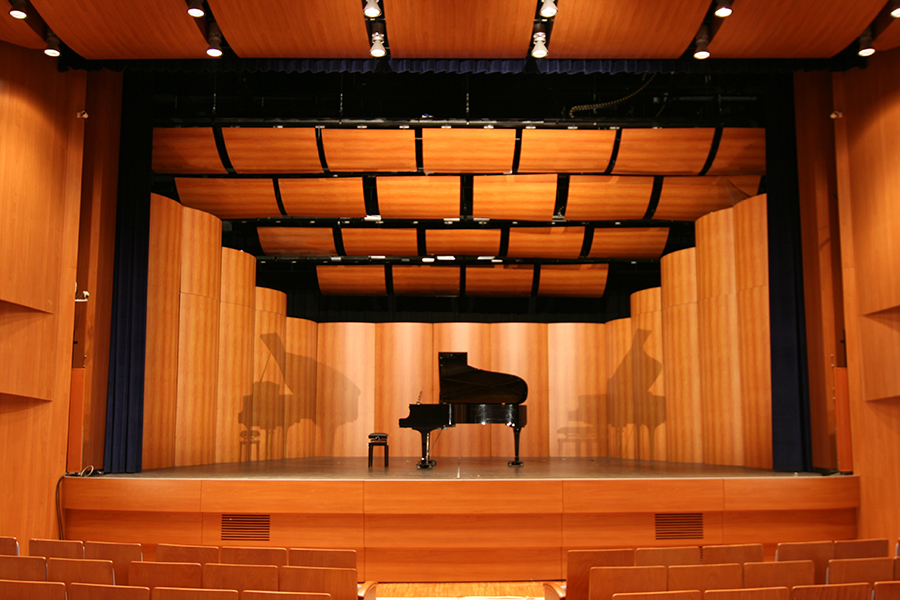Palcoscenico del Teatro Cristallo di Bolzano con pianoforte a coda e pannelli acustici in legno