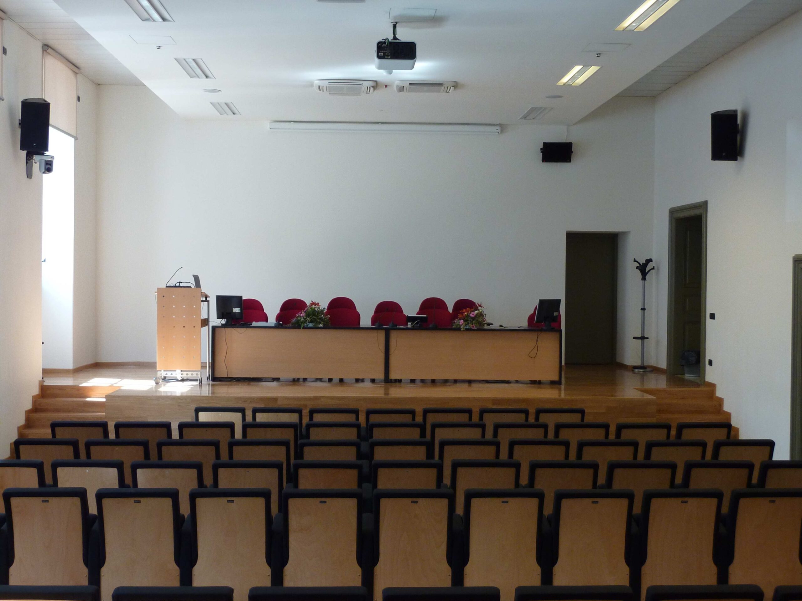 Sala conferenze dell'Universita di Trento con sedute, podio relatore e impianto audio con diffusori