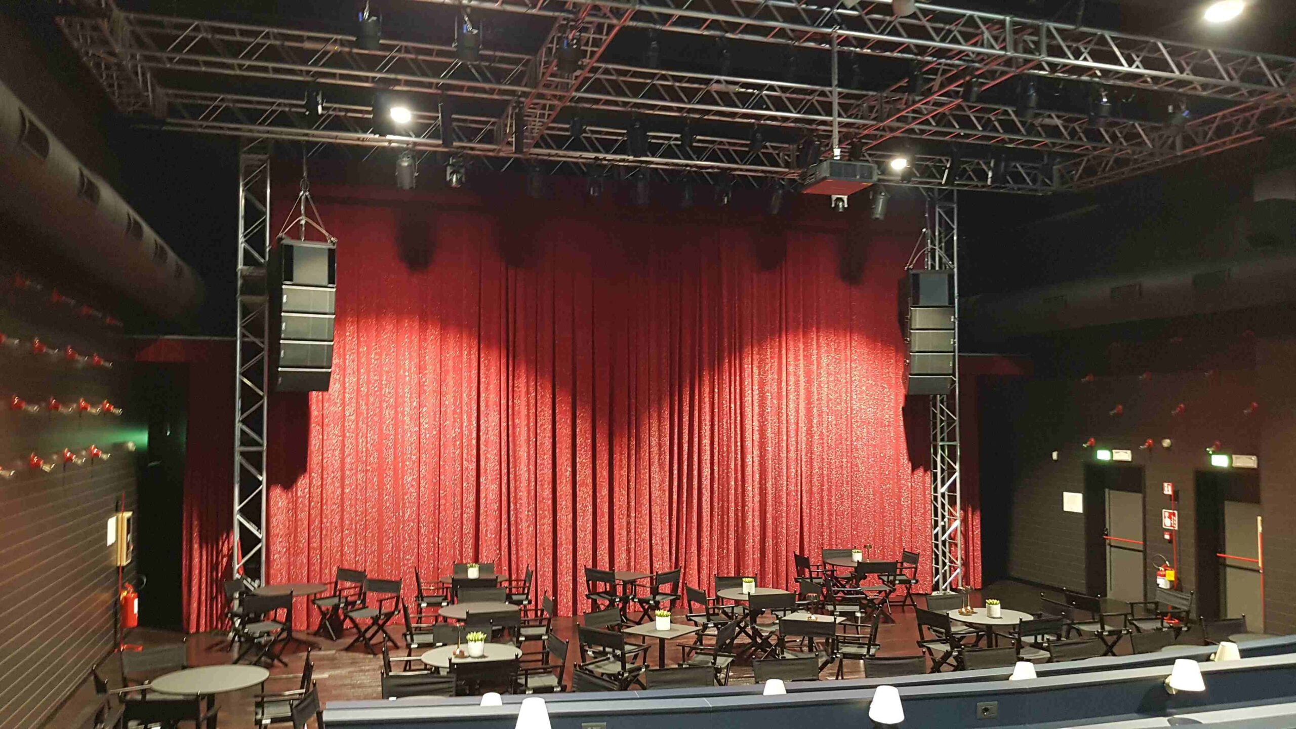 Palco dello Zomby Club di Inveruno con sipario rosso, line array e tralicci per illuminazione