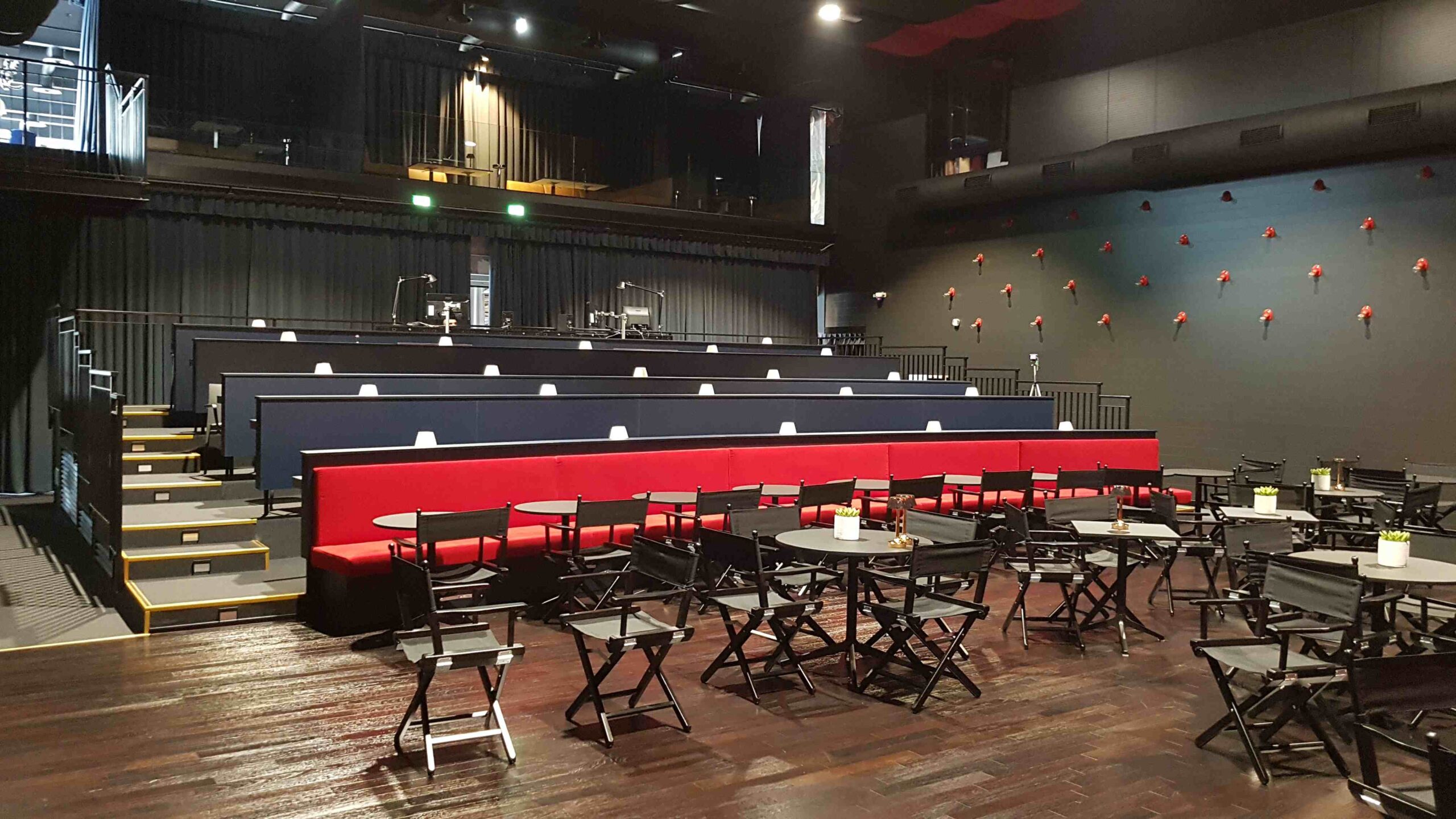 Zona lounge dello Zomby Club di Inveruno con divani rossi, tavoli, sedie e palco sullo sfondo